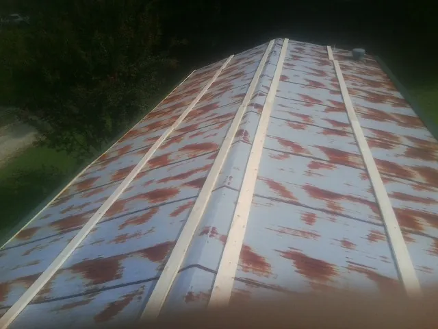 Rusted metal roof panels with new wood purlins before replacement — Storm Damage Roof Repair in Yellow Spring by Roofing Brothers