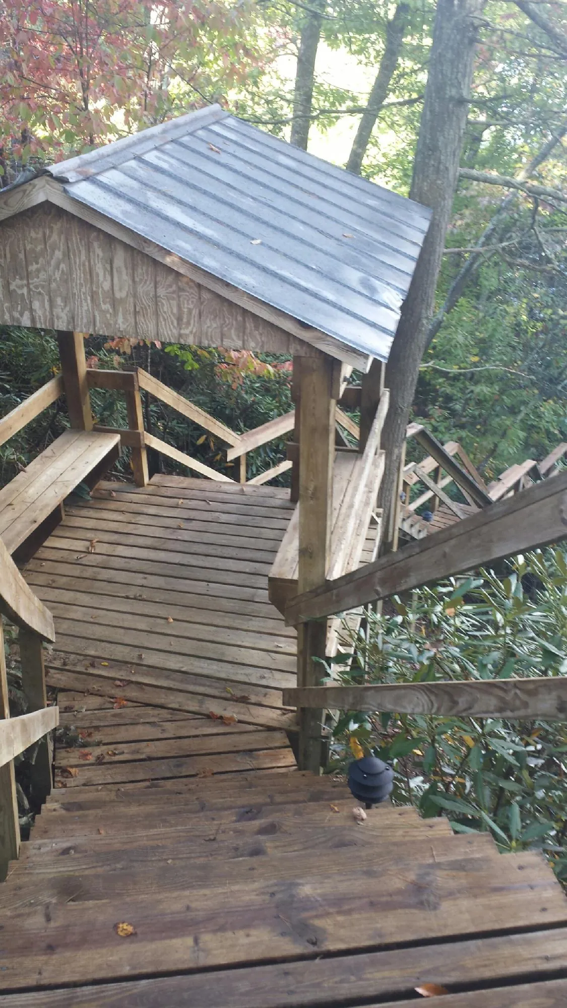 Metal roofed shelter over wooden steps on a wooded walkway — Skylight Repair & Installation work by our crew in Yellow Spring