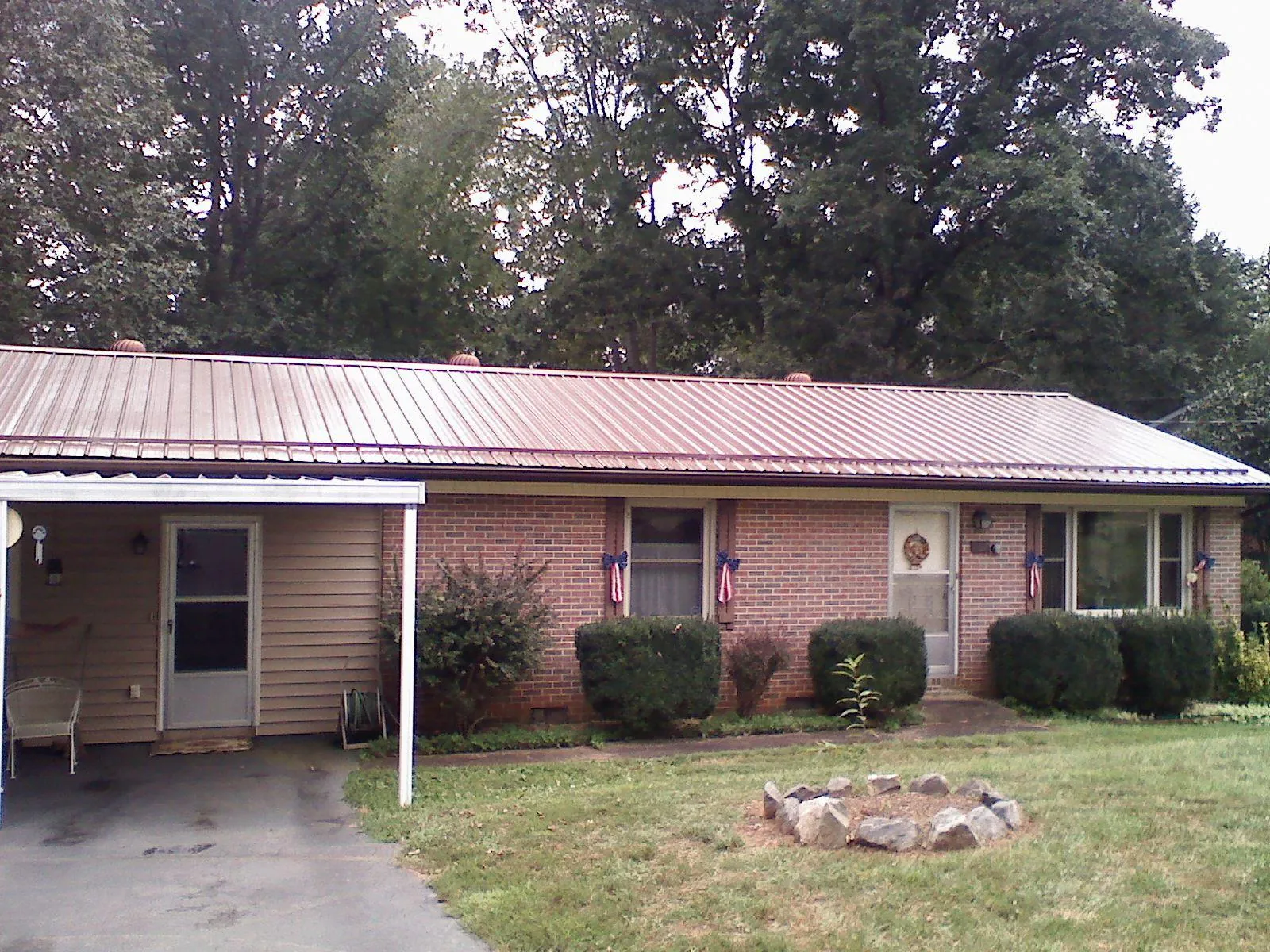 Bronze metal roof and carport on a brick ranch home — Roof Repair work by our crew in Yellow Spring